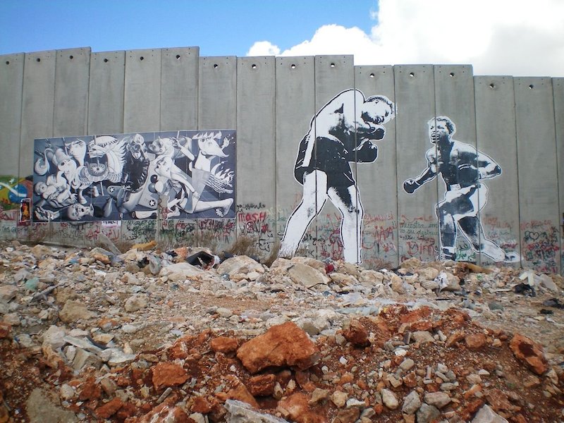 Work put up by Ron English and Faile on the separation wall in the West Bank as part of Banksy's Santa's Ghetto project in Bethlehem. Photo by eddiedangerous.