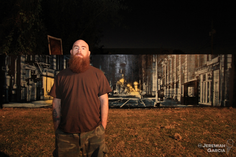 Logan Hicks with the mural he painted for Wynwood Walls in Miami, Florida in 2010. Photo by Jeremiah Garcia.